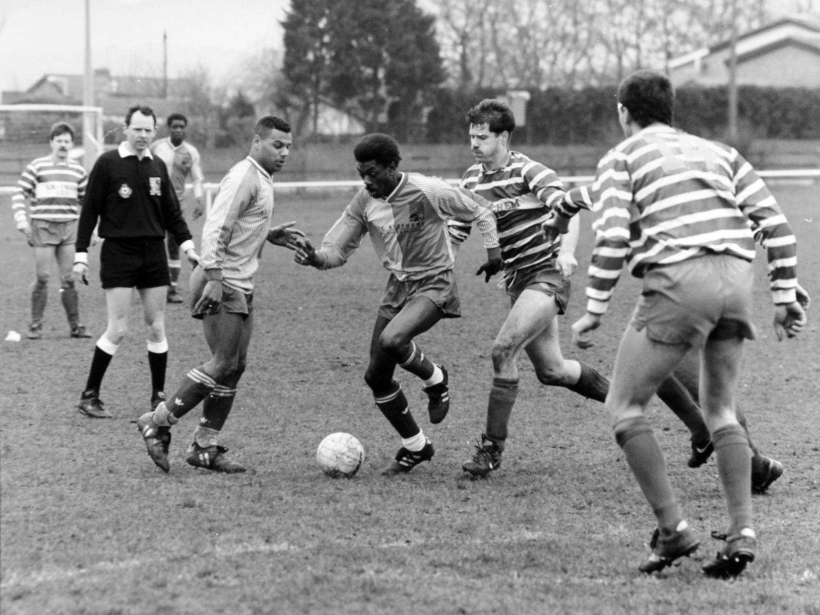 Oliver French of Fforde Grene tries to make an opening in the Holbeck B. C. defence in the semi-final of the Leeds Combination League's Sanford Trophy. Holbeck won 2-1.
