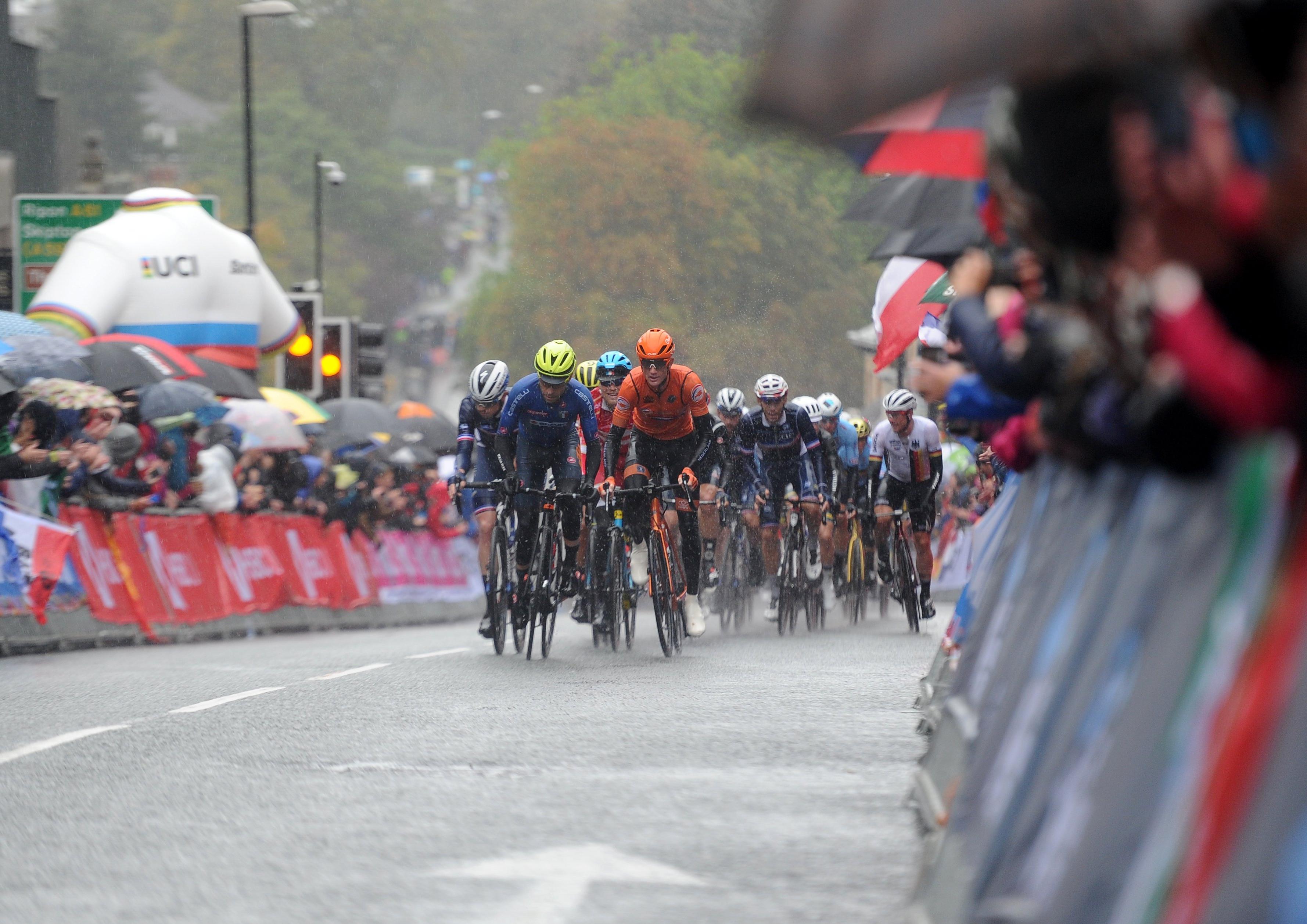 Spectators watch in the pouring rain