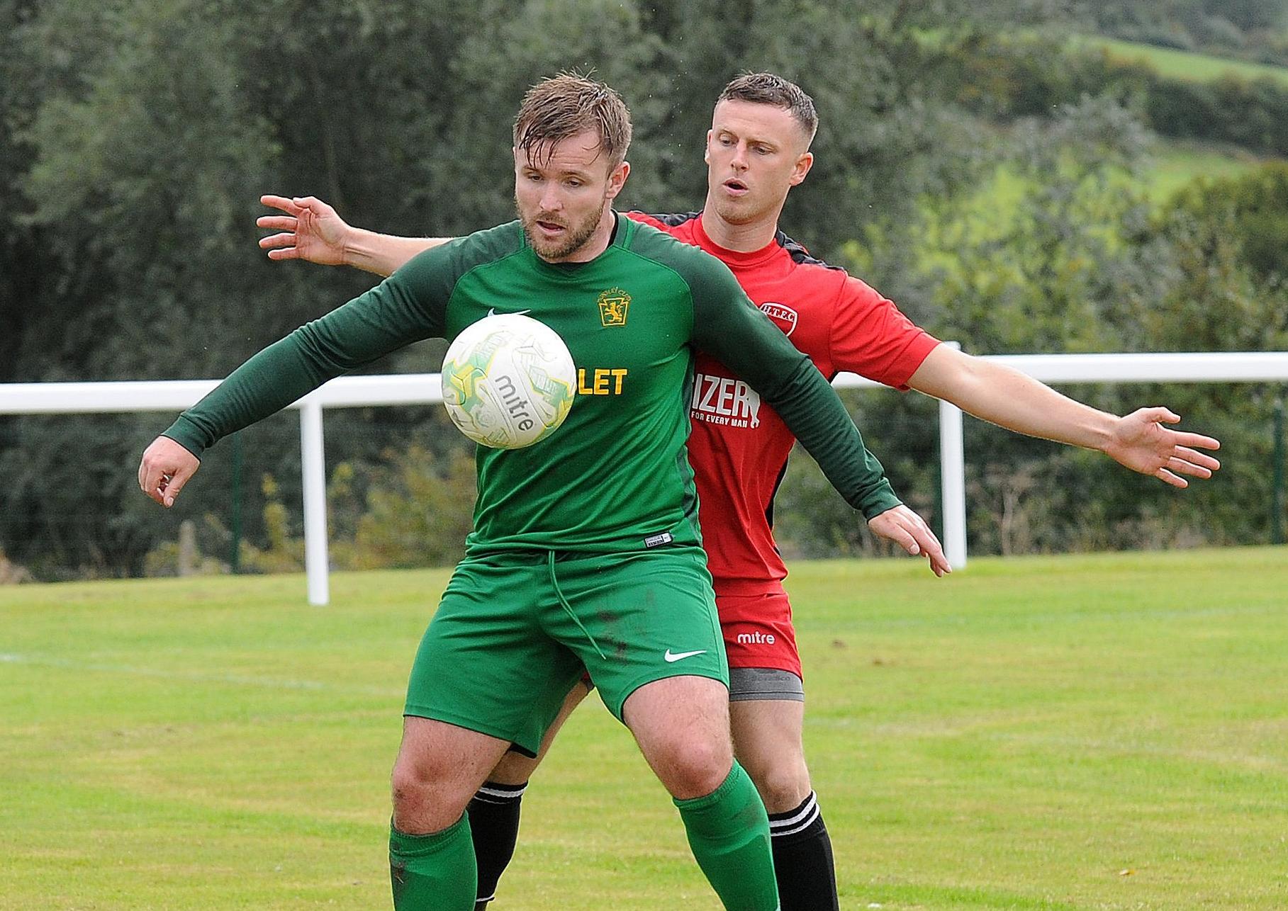 Kieran Corley of Hunslet Club holds off  James Wilson of Horbury Town.