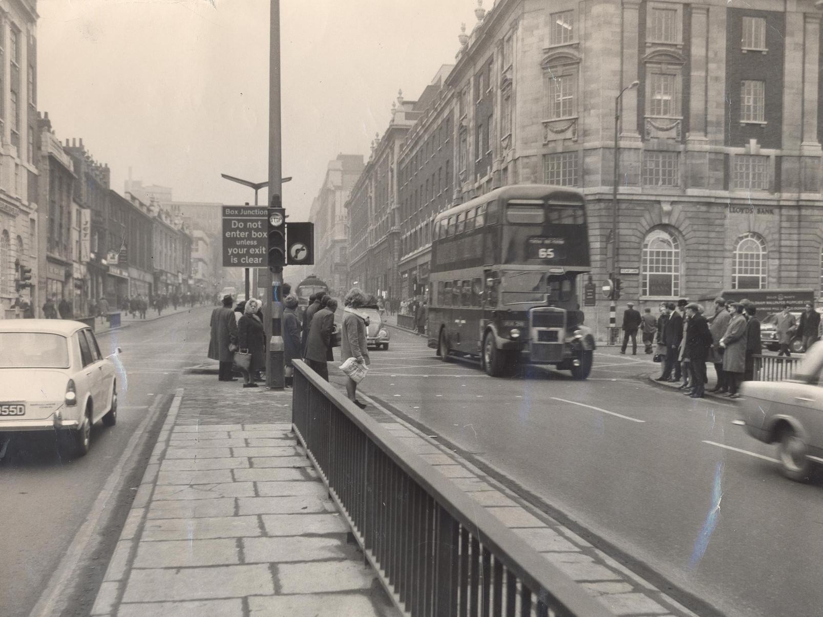 Pedestrians wait to cross the junction of Eastgate, The Headrow and Vicar Lane.