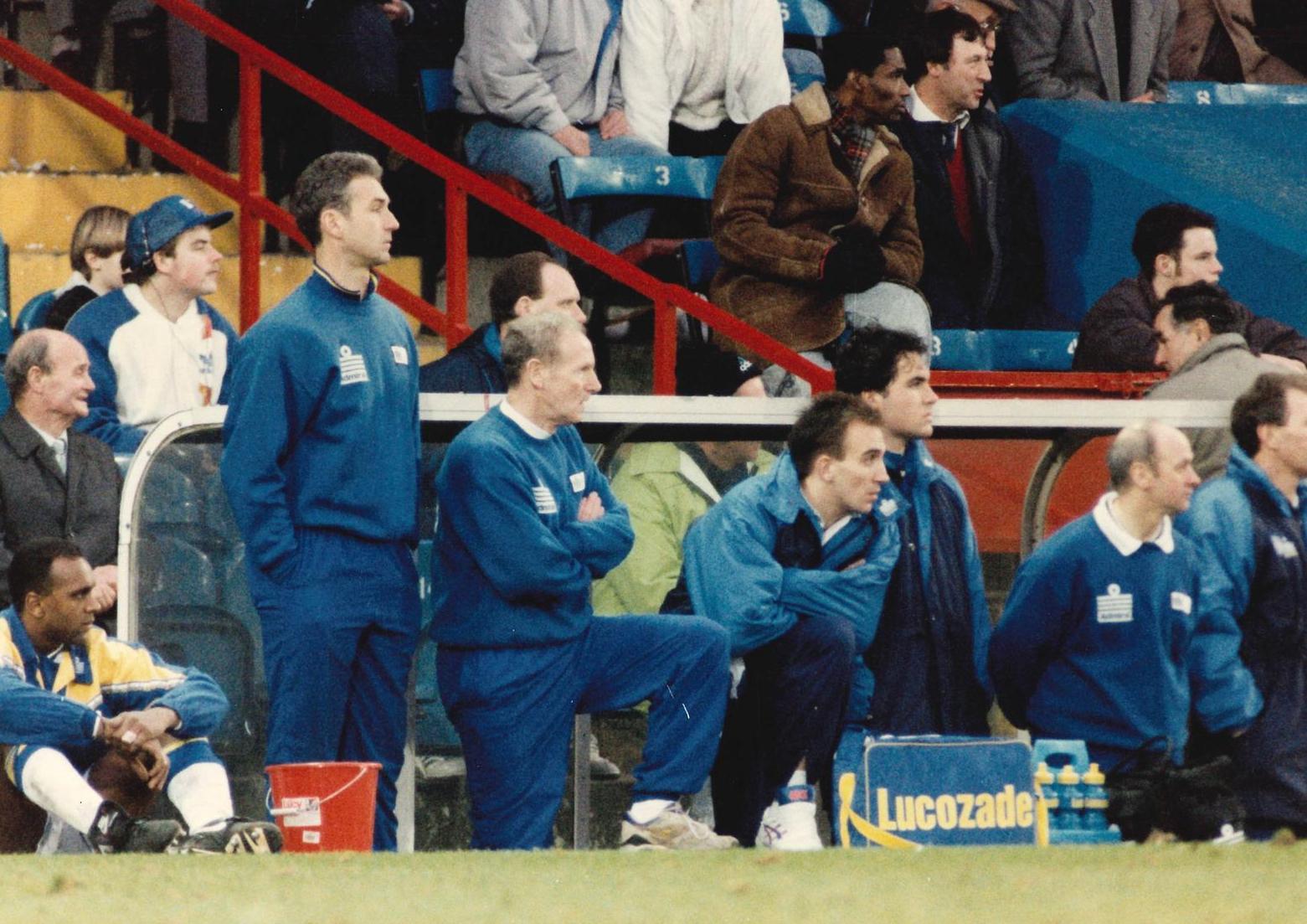 Midfielder David Rocastle sits it out at Selhurst Park after being substituted. Also watching (left to right) are Mervyn Day, Mick Hennigan, Sean Hardy (kit man), Frank Strandli, Alan Sutton and Sgt Wilko.