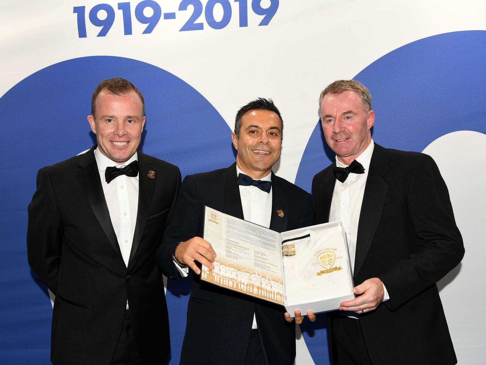 John Sheridan, right, being presented with a personalised replica of the Leeds United centenary kit by owner Andrea Radrizzani, centre, and managing director Angus Kinnear (Pic: Jonathan Gawthorpe)