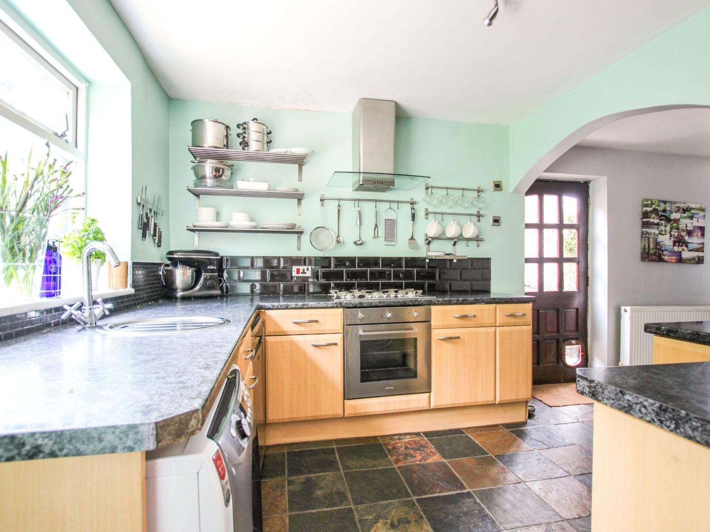 Spacious kitchen having a range of modern base and eye level units with work surfaces, ample space for a dining table and chairs, double glazed window to the rear elevation and access to the rear garden.