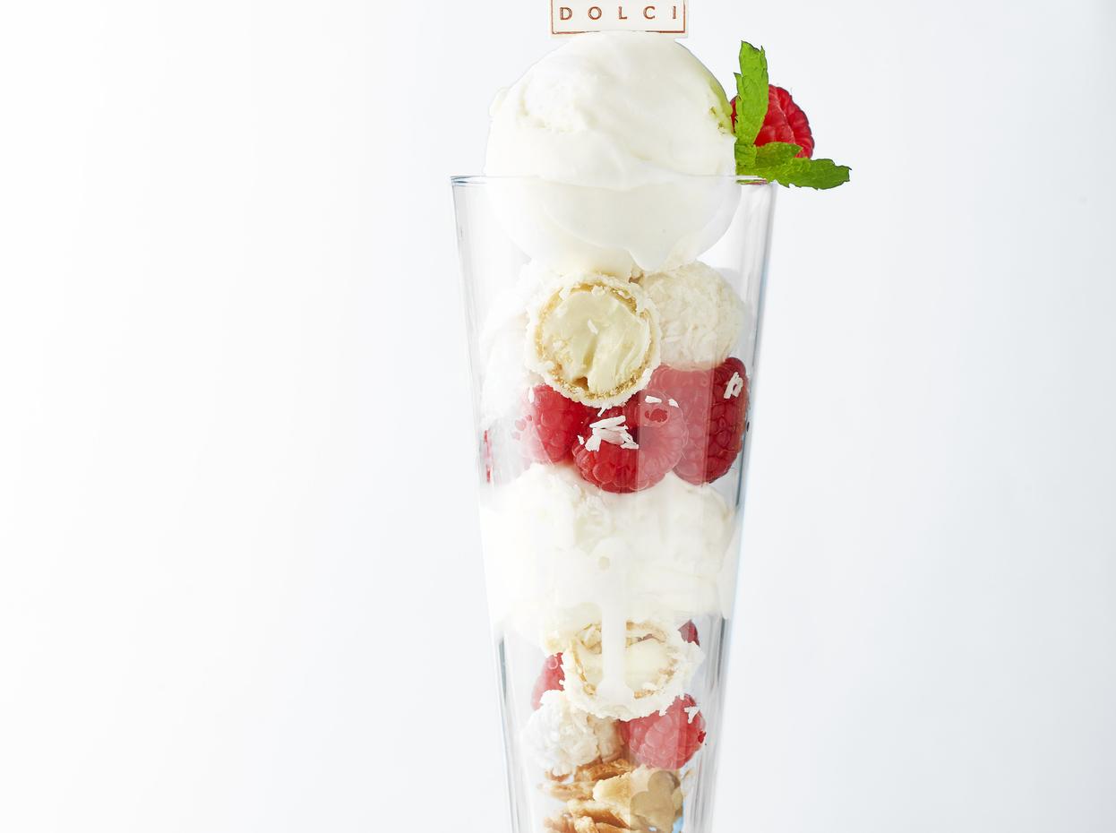 Experience Caribbean style flavours with the La Dolci Vita sundae. Two scoops of coconut gelato, served with white chocolate, a raspberry tart sauce and topped with raspberries, white chocolate pearls, and Raffaella chunks.
