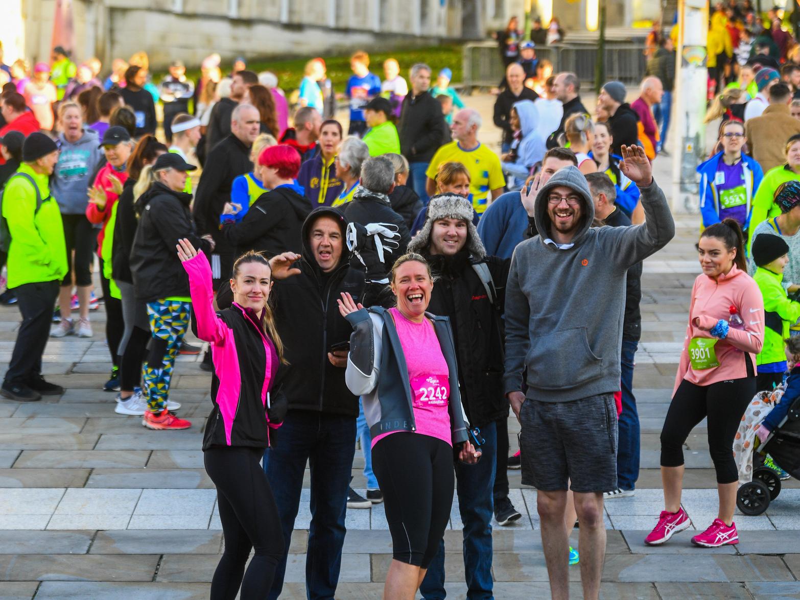 Runners wave at our photographer.