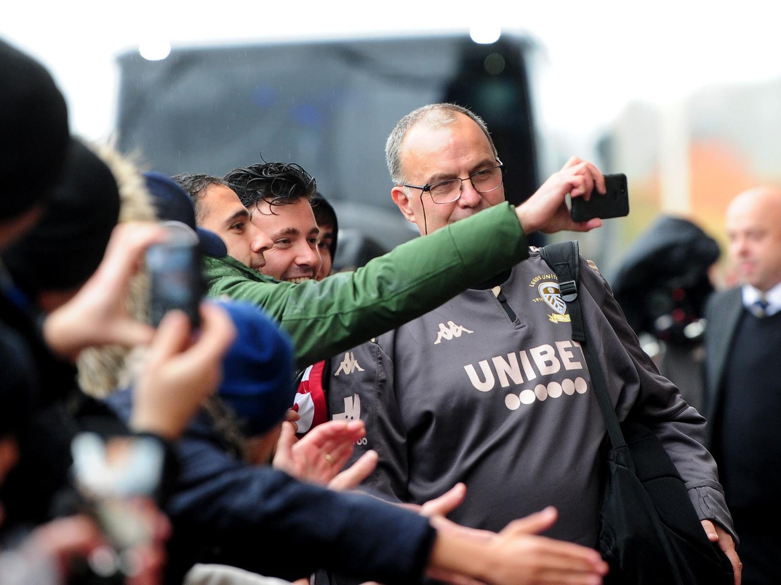 Marcelo Bielsa poses for a picture with fans as the team arrives at the ground.