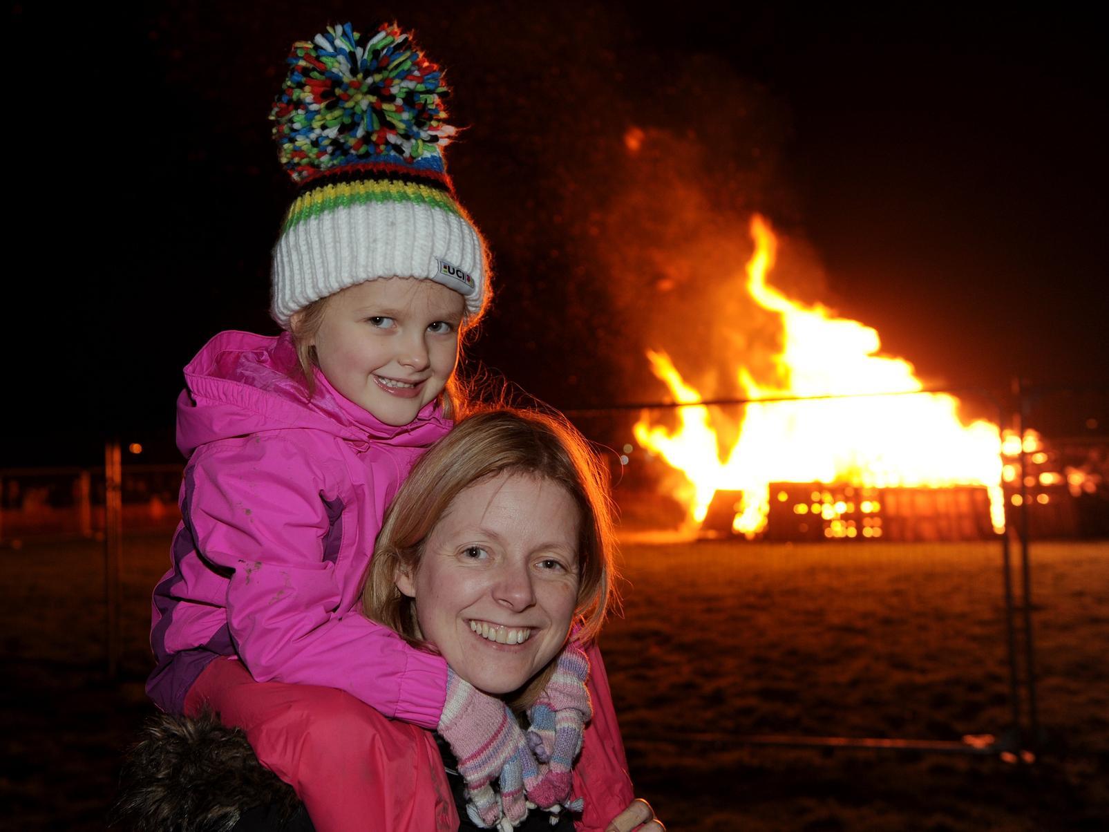 Four-year-old Charlotte Miles with her mum Heather watching Charlotte's dad light the bonfire.