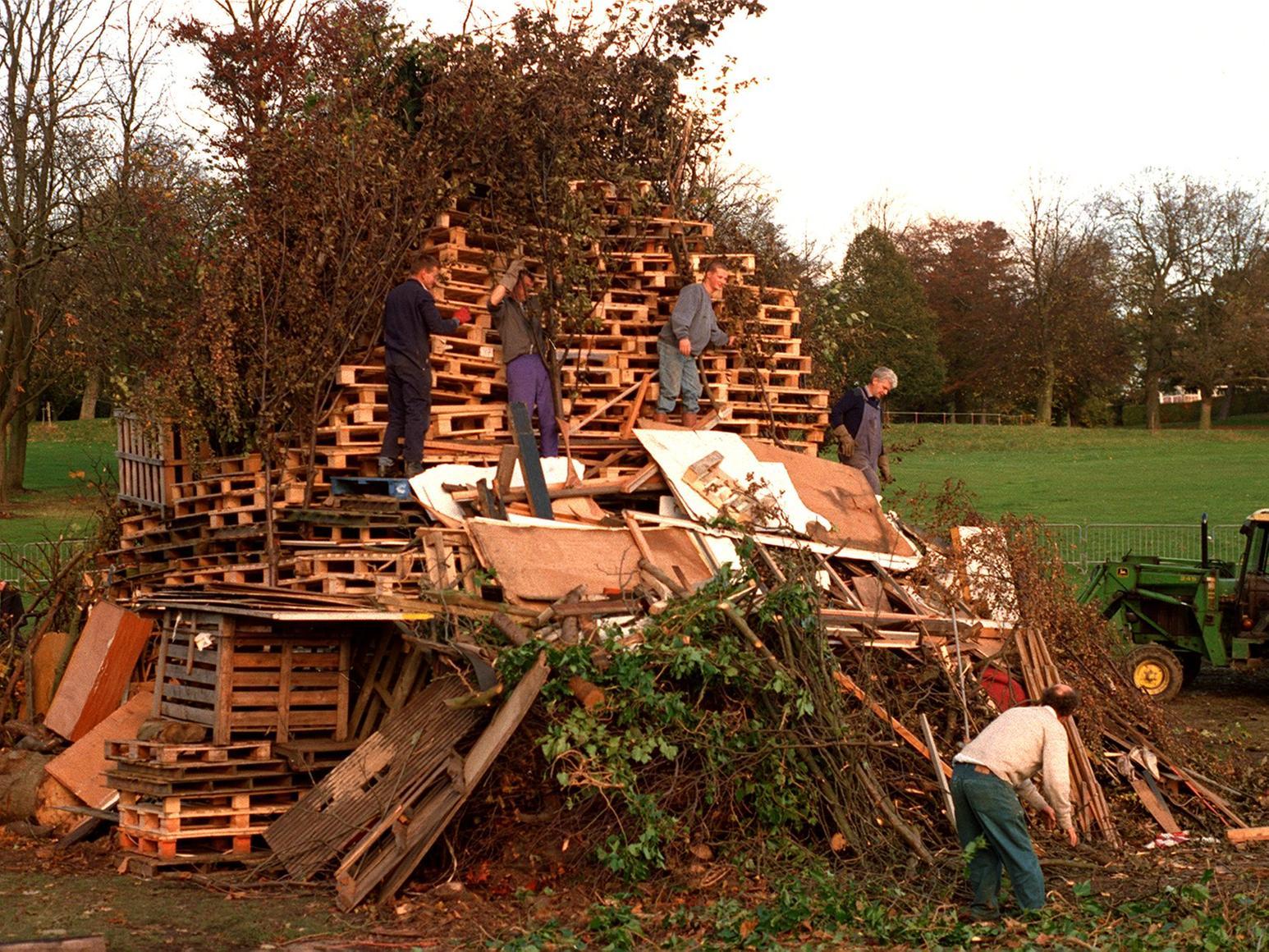 Workers gather the donated wood at Roundhay Park into a bonfire shape.