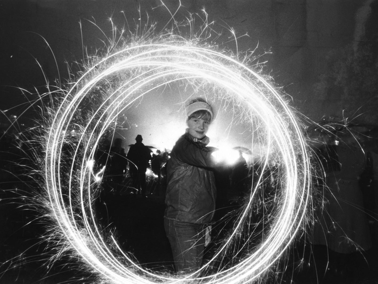 Dawn Wheatley puts a dash of sparkle into the wet Roundhay Park bonfire in November 1982..