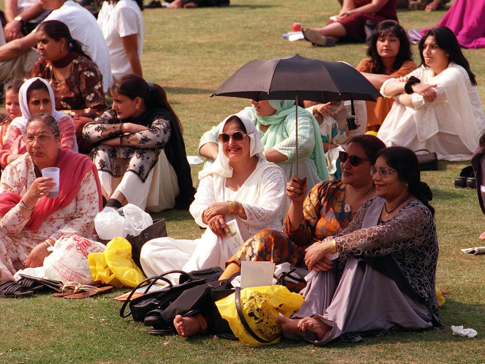 Some of the visitors at Leeds Mela tried to keep cool in the sun by using an umbrella at Roundhay Park.