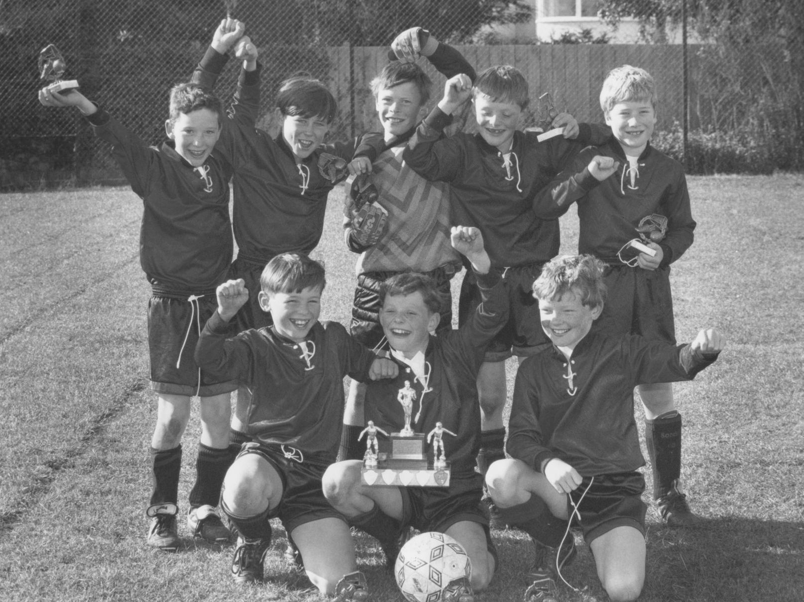 The winning team of the seven a side football tournament in October 1996. Filey Junior School pupils hold their trophies aloft, from left, back, Mathew Bedson, Nicholas Mitchell, Alistair Wilkins, Phillip Dickens, Robert Farnell; front, Joseph Powell, captain Stuart Dickens, and Alan Wright.
