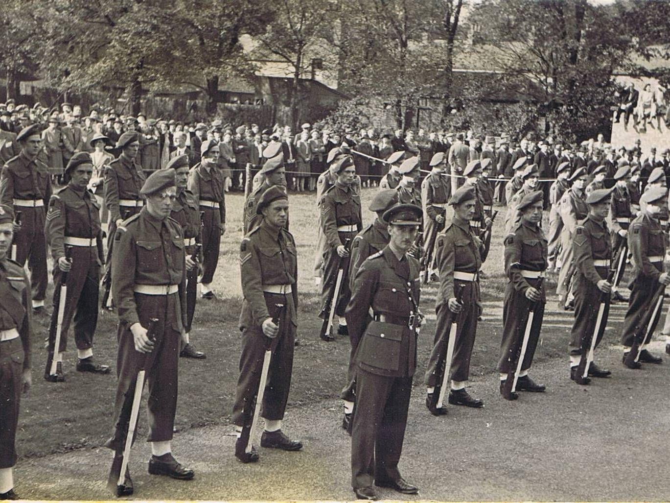 A platoon of Green Howards soldiers standing at ease in the gardens, at the official ceremony for the presentation of the Bridlington scroll and bowl in 1945