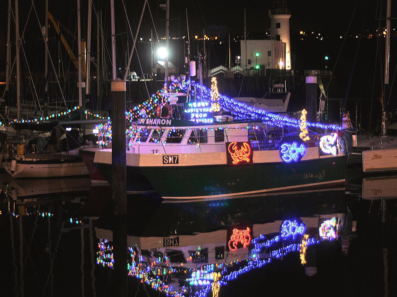A boat on the harbour lit up for Christmas.
