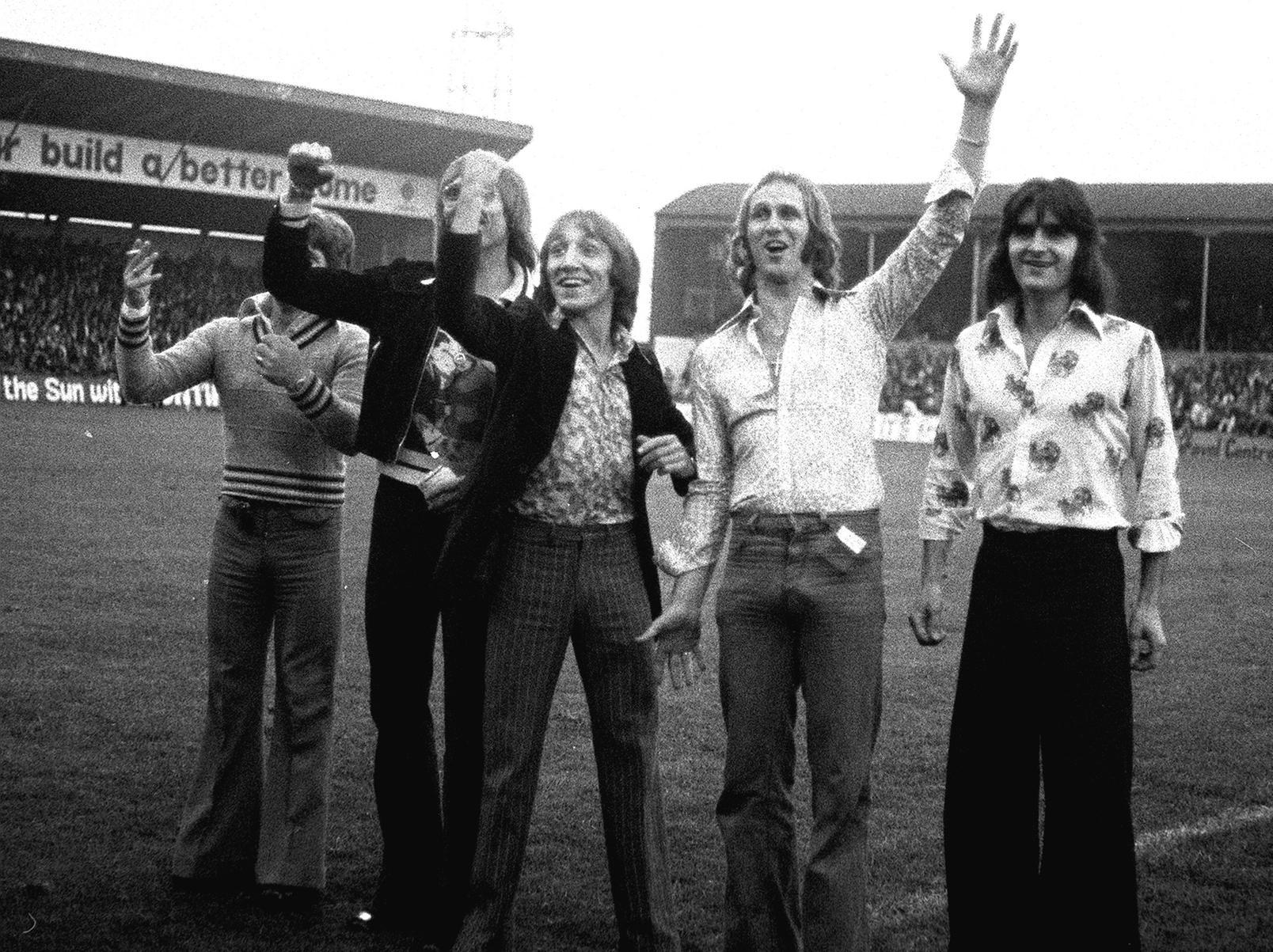 Five PNE fans on the pitch at a game in the 1970s