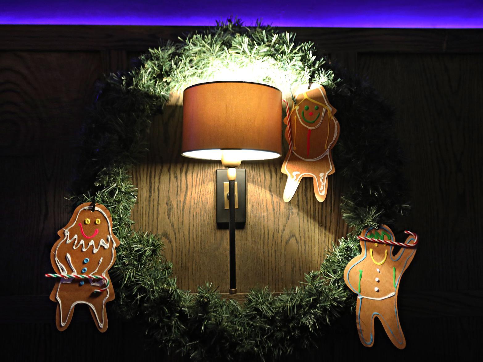 Three little gingerbreads surrounding a lamp.