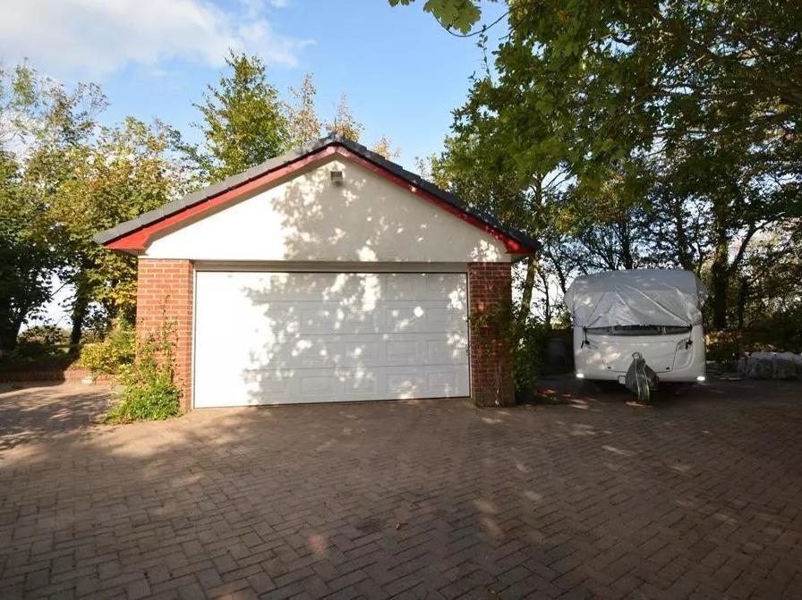 A block-paved driveway has ample off-road parking and leads to a detached double garage with remote controlled door.