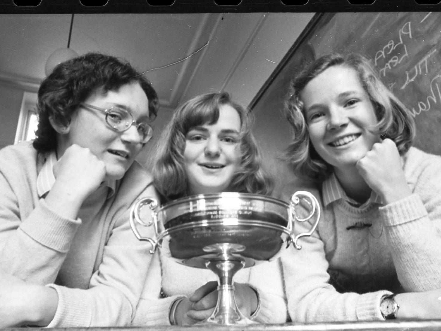 It was all smiles for this trio when they were presented with gleaming silverware for their efforts in a public speaking competition at Queen Marys School, Lytham. The team were pictured on  November 29 1974