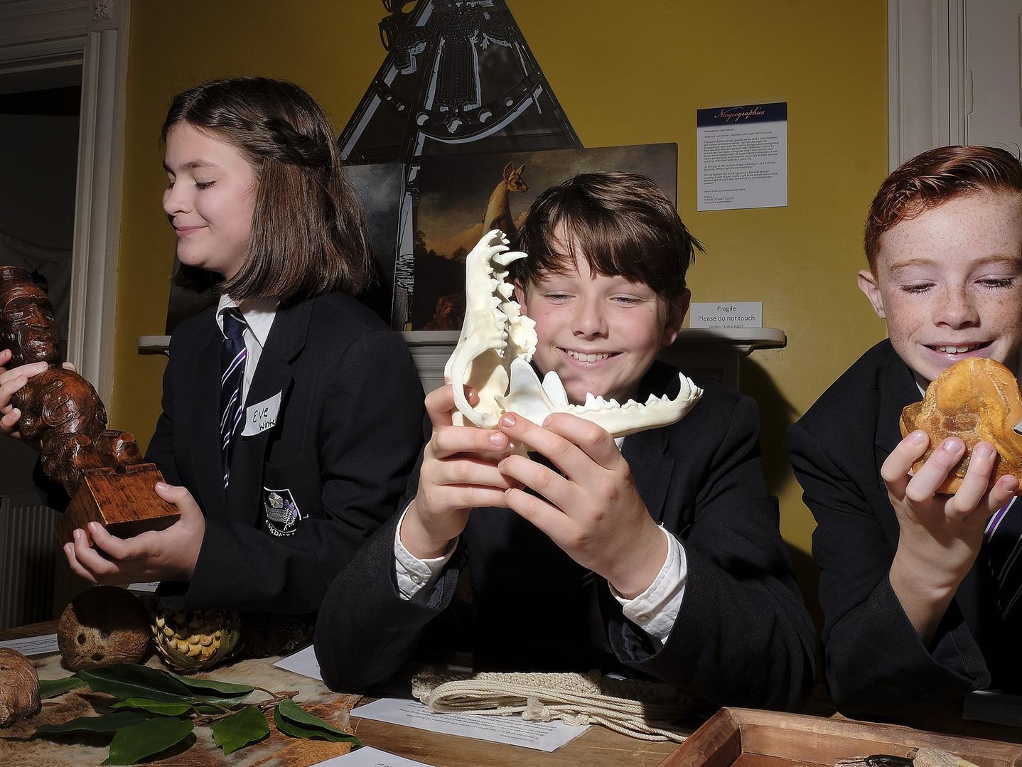 Students Eve, Finley and Marcus have some hands-on experience with artefacts, 1950140c.
