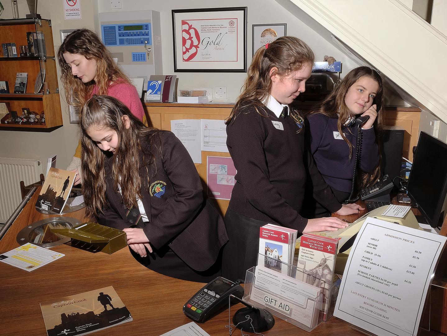 Volunteer Kirsty Davis with students Gracie, Emily and Jet working in reception, 1950140d.