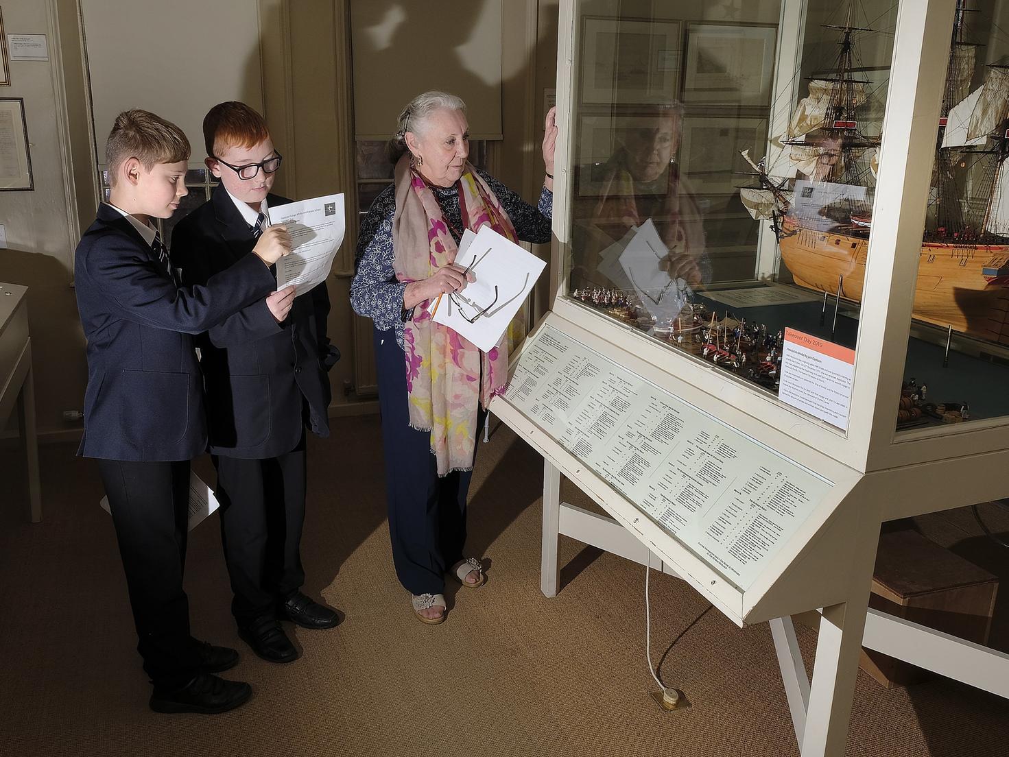 Students Charlie and Jack with Volunteer Coreen Parkinson in one the display rooms, 1950140b.