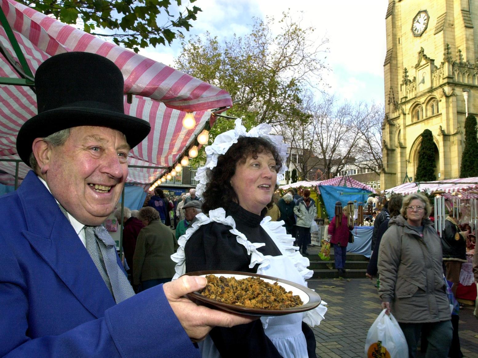 Stallholders Lewis Wood and Bridget Lee hand out samples of Christmas cake to shoppers at the Victorian Christmas Market at the Cathedral precinct, Wakefield.