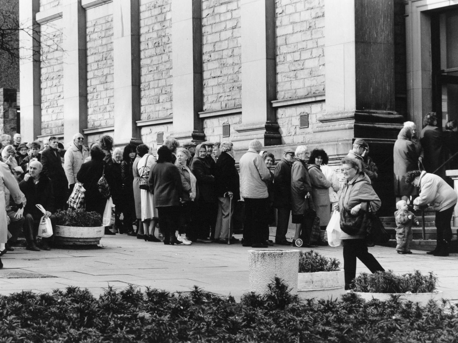 Residents wait to collect cheap European Community food packages at Morley Town Hall.