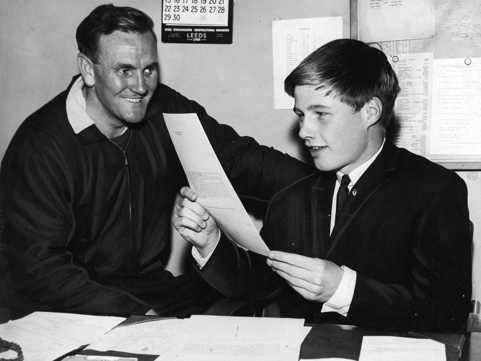 Young Jimmy Lumsden is seen reading his form, watched by team manager Don Revie.