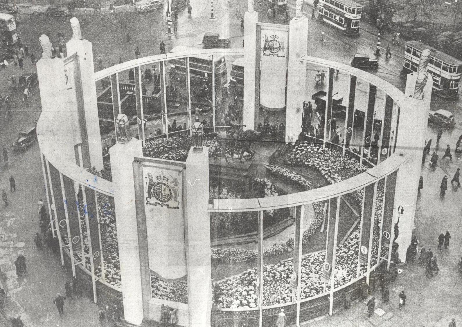 A photo taken from the top of the Queens Hotel showing the elaborate Coronation decoration scheme in City Square. The owls on top of the pylons are the civic emblems and the gardens are laid out with specially grown flowers and plants.
