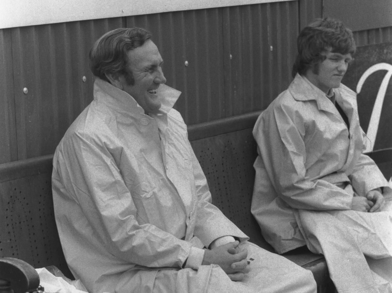 Don Revie manages a smile despite the rain as he watches Leeds United kick off