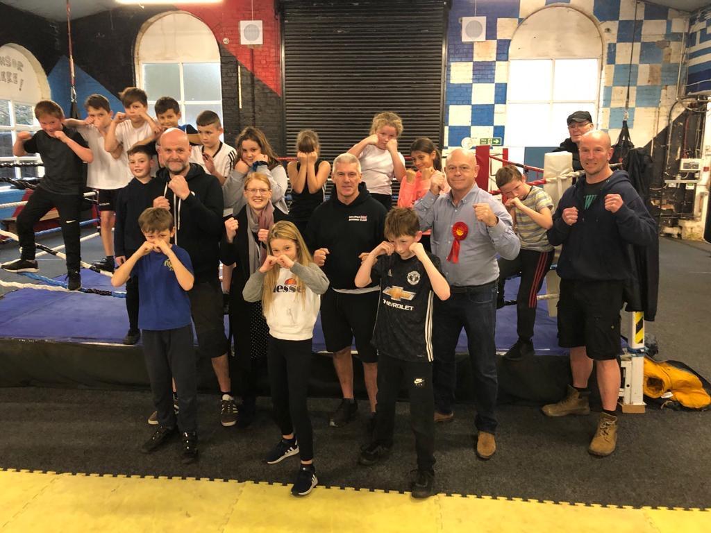 Mr Kemp poses with young members of the boxing club