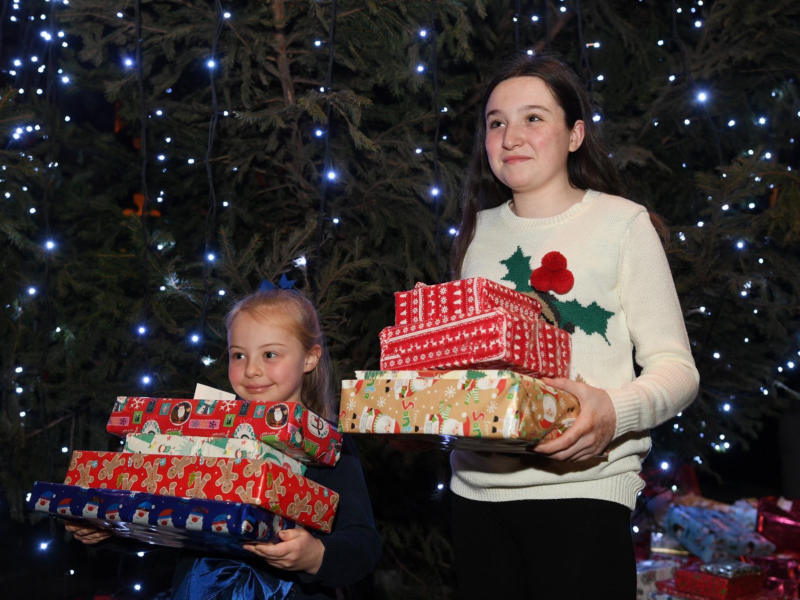 Emily Young (7) and Niamh Walton-Foulds (12) put presents under the tree, which will be passed to Leeds Councils social services department and under-privileged children