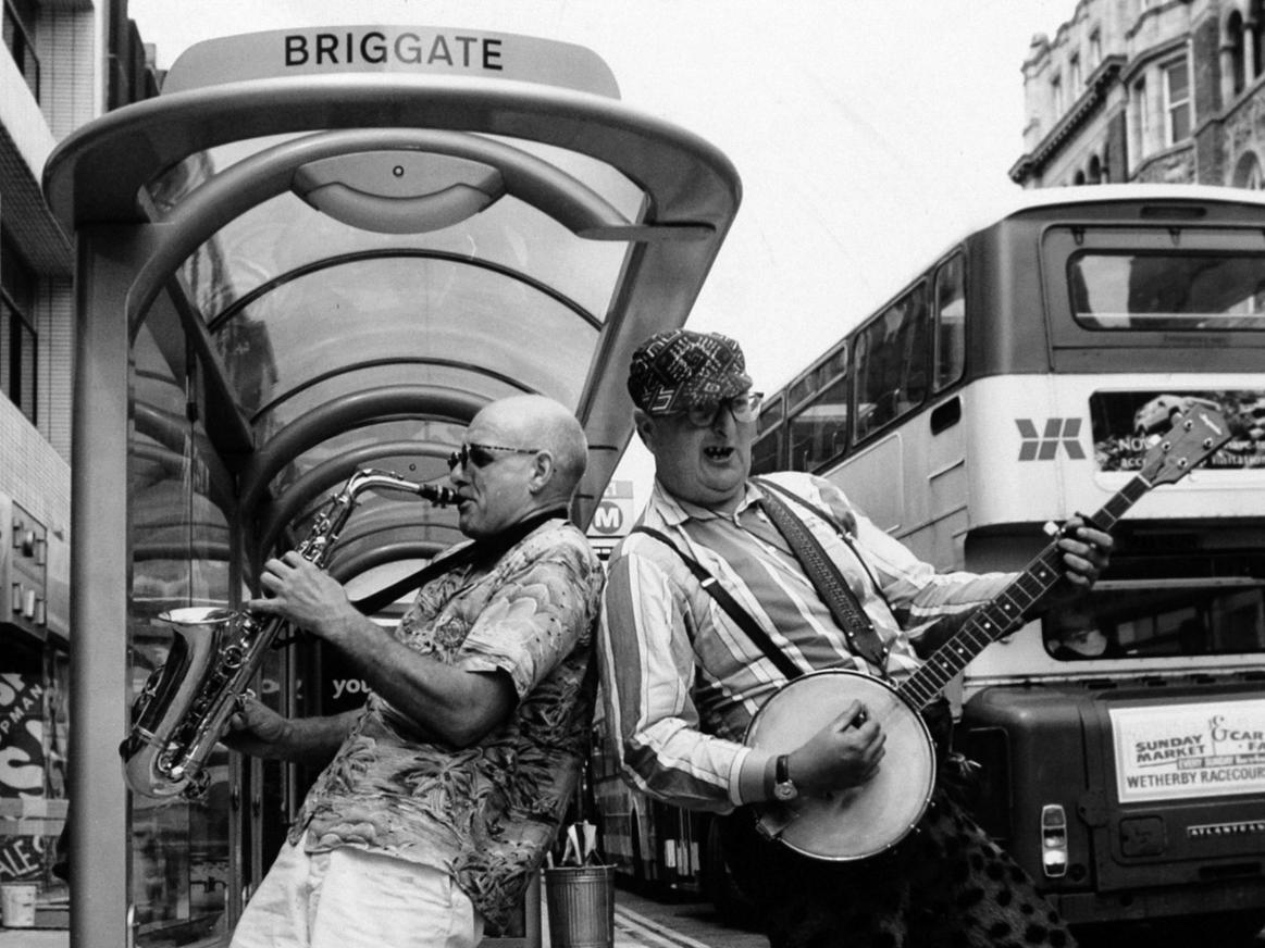Buskers Moon de Lune take their two-man act on a bus-stop tour of Leeds, part of a 50-mile trip to nine different town centres as a prelude to the Leeds Centenary Wind Festival.