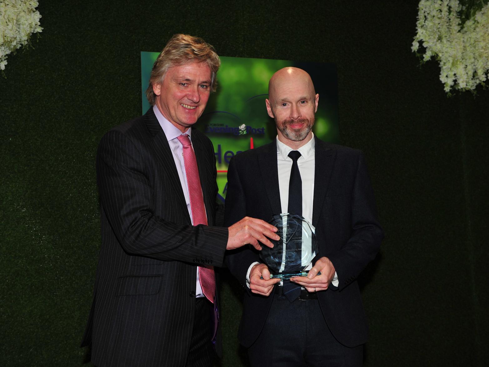 Russ Piper, chief executive of Sovereign Healthcare, presents the trophy to Paul Butler, who wins the Mental Health and Wellbeing Award, for his work supporting mental health patients in Leeds.