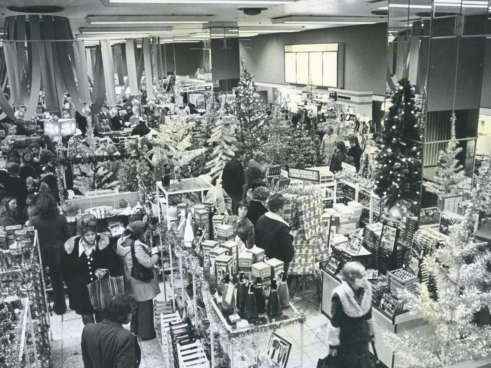 A bustling town centre department store is pictured with all its Christmas wares as shoppers grabbed their last minute gifts in 1983