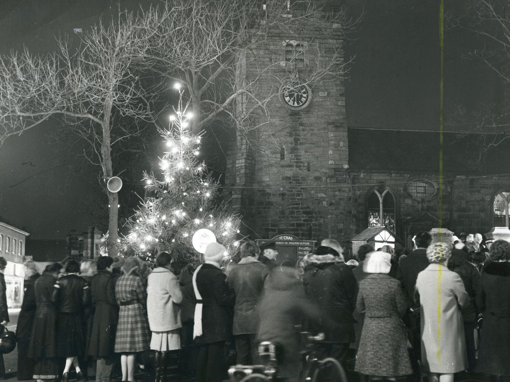 Carollers round the Christmas tree outside St Chads Church in Poulton, 1976