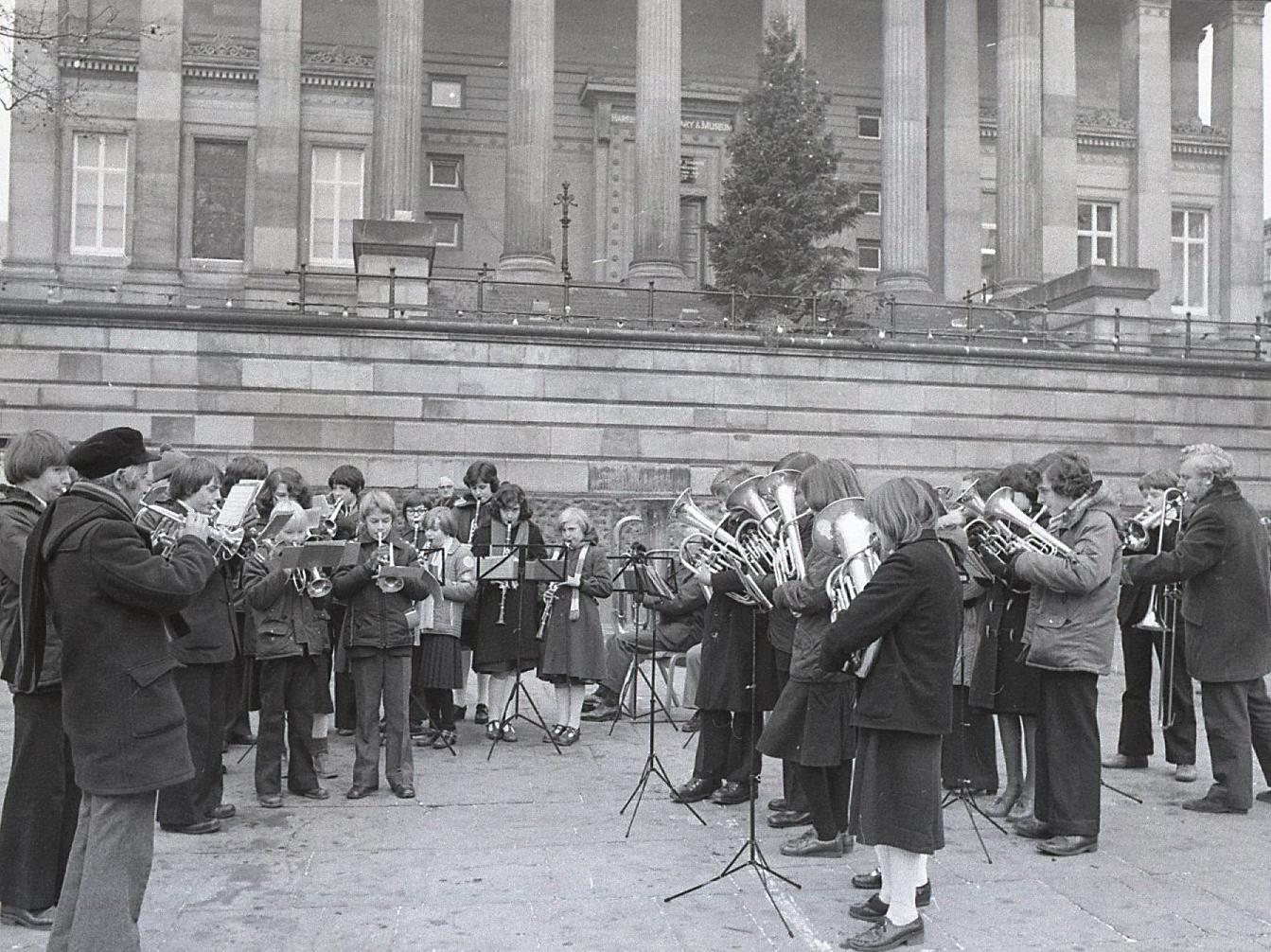 Providing a Christmas treat for the passing throngs of shoppers requires a great deal of concentration, as well as huff and puff - as this pictures shows during Tulketh  High School Band's carol outing to Preston Flag Market