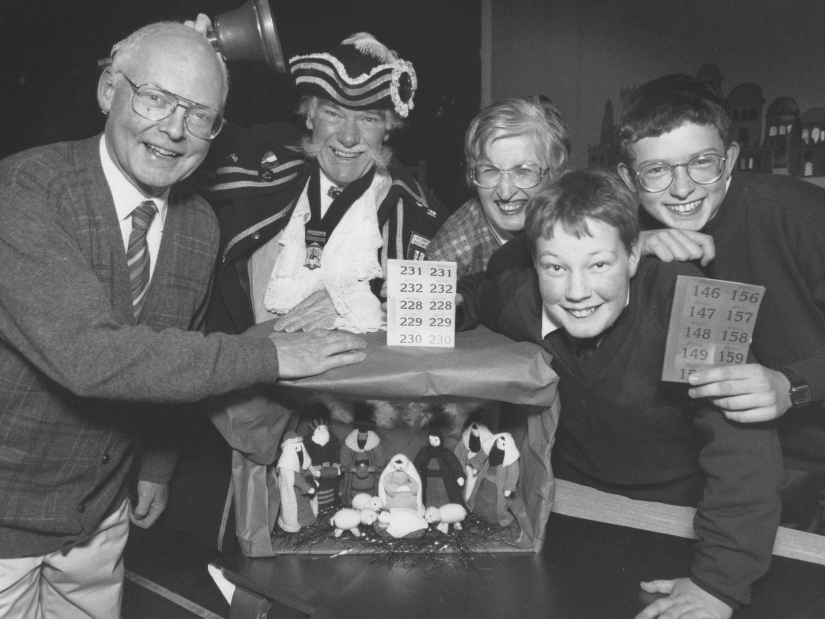 Joining forces to raffle a Nativity set at St Augustine's Christmas fair in December 1997 are head teacher Keith Bear, town crier Alan Booth, Mrs Jean Bear, and pupils Chris Fletcher and Robert Bear. Mrs Bear also made the Nativity set.