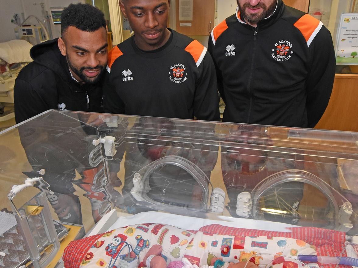 Players Sullay Kaikai, Curtis Tilt and Mark Howard with Sienna Weaver who was born 10 weeks premature weighing 2lb 6oz