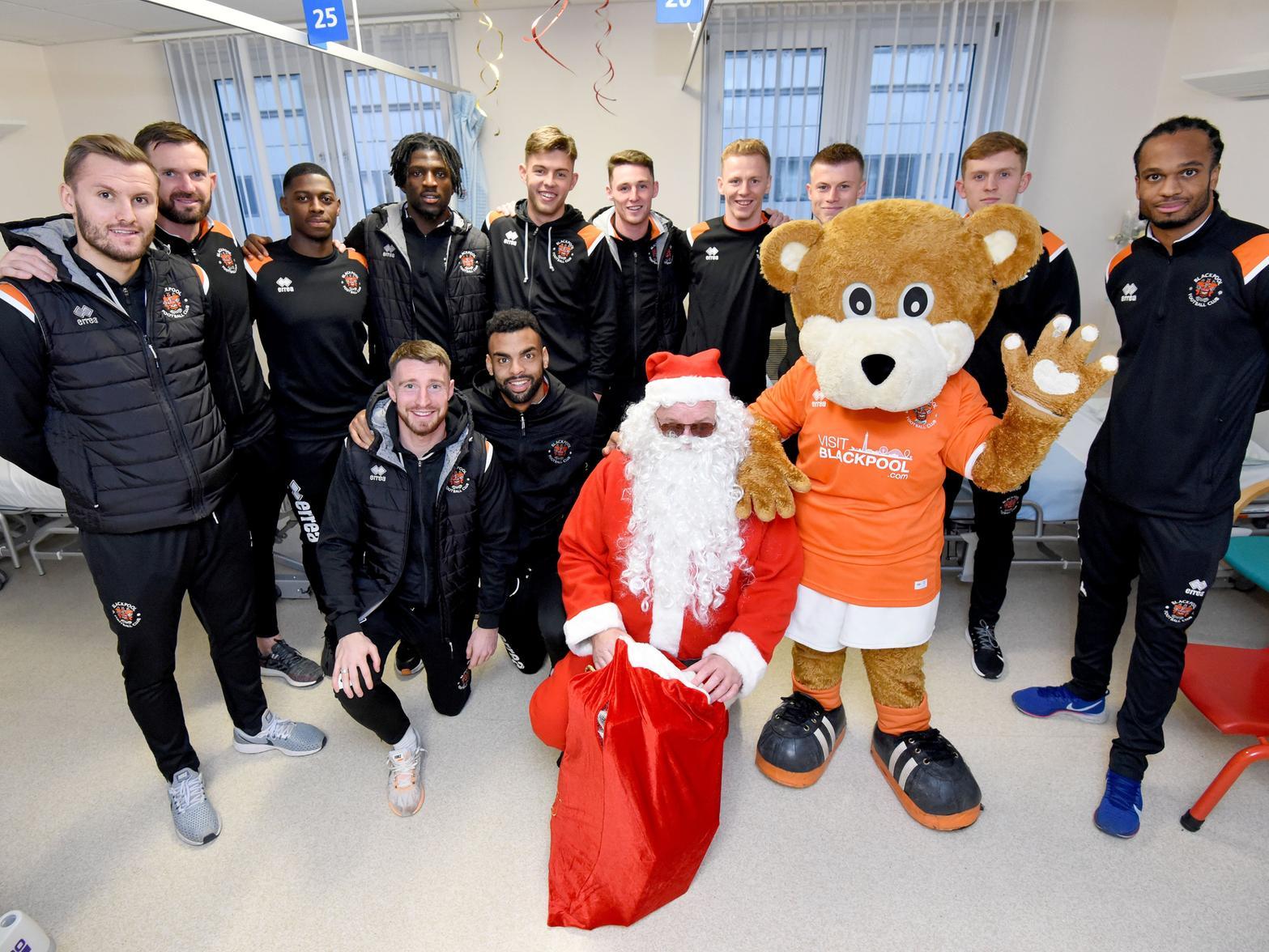 The players pose for a picture with Father Christmas and Bloomfield Bear on the children's ward