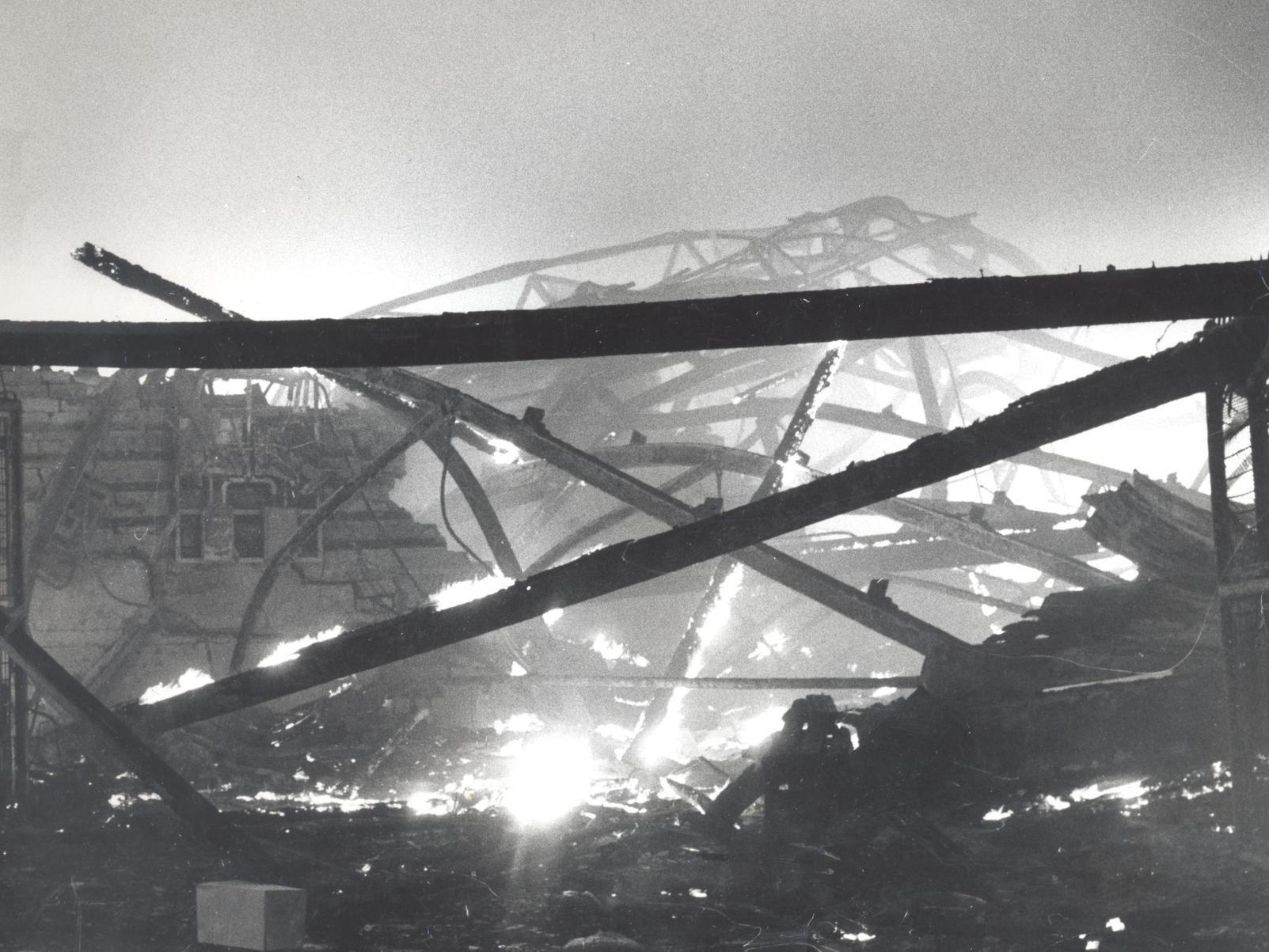 A jumbled maze of twisted girders cools from white-hot incandescence as the blaze dies down.