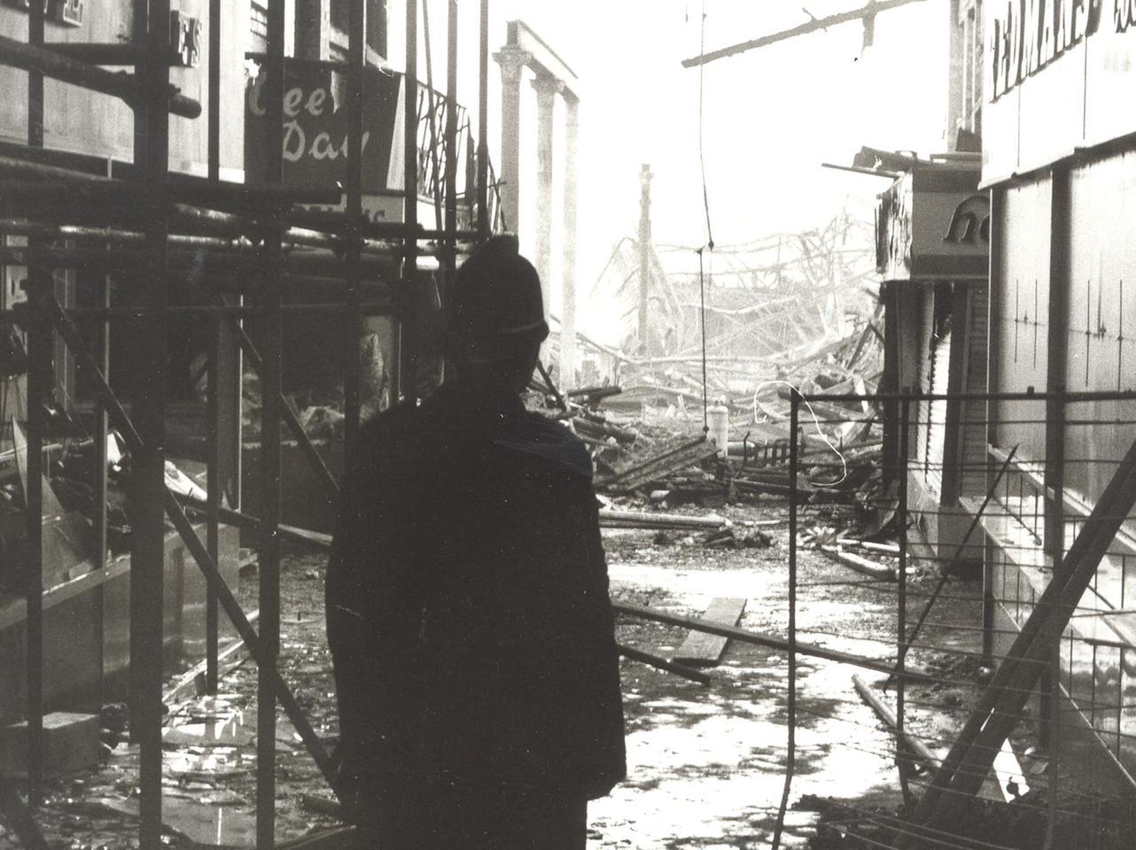 A policeman looks at the extent of the damage in this atmospheric photo.