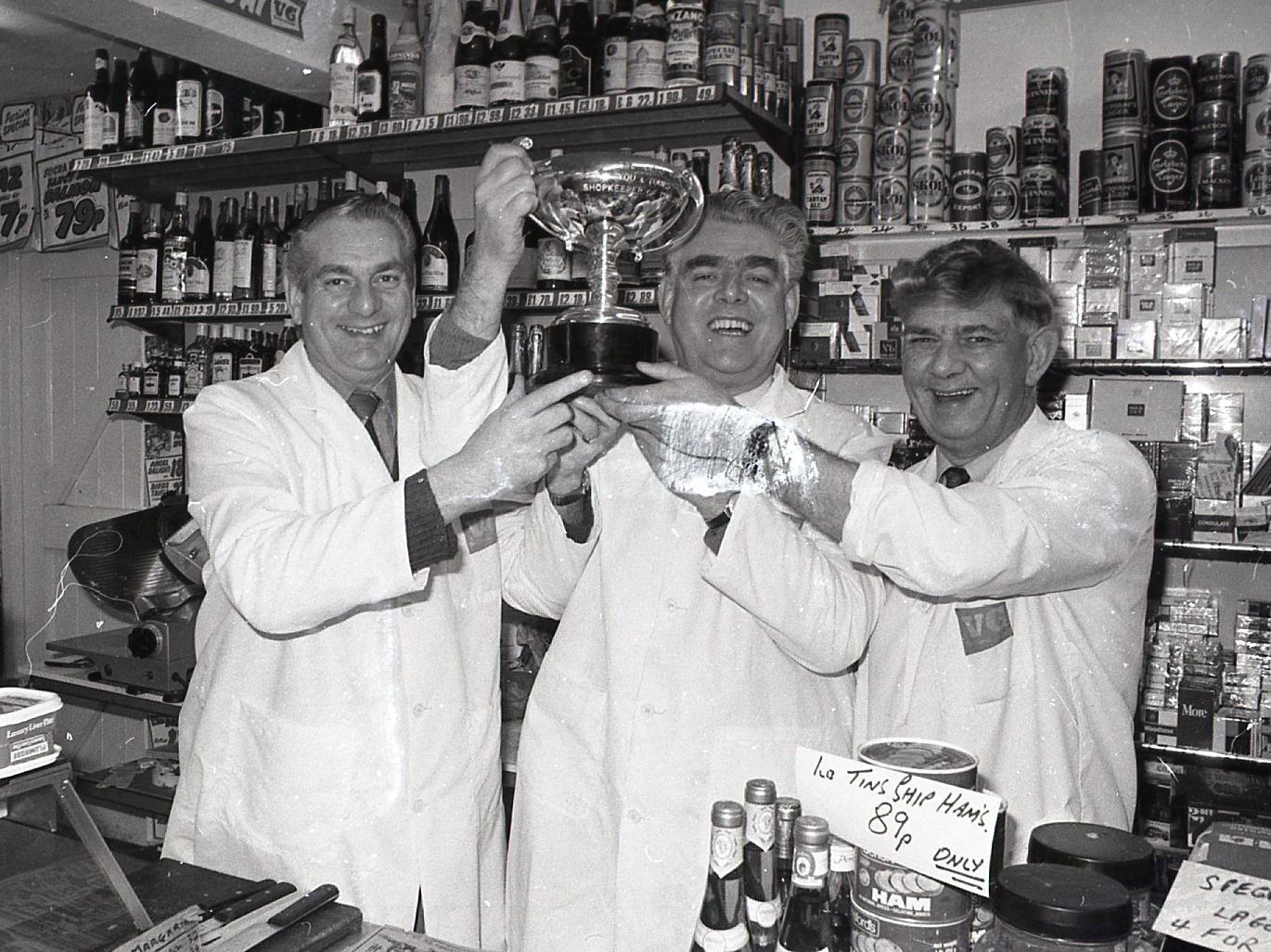 We are the champions... grocers (from left) Adrian, George and Bill Dobson. These three Fylde brothers line up in the village store which won them the BBC's new "Shopkeeper of the Year" title. Tucked away in picturesque Wrea Green, Dobson's boasts the best grocers in England
