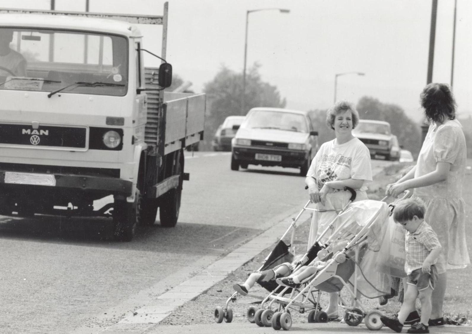 Young mums wait to cross the busy ring road at Broadway, Horsforth.