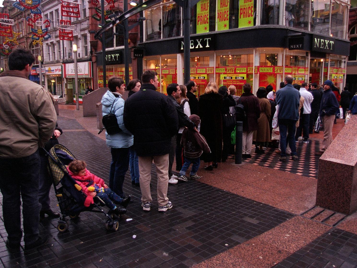 Shoppers queue outside Next in the city centre.