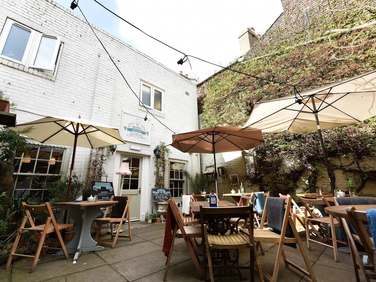 A reviewer said:
Blink and you'll miss it, but go down the passageway to find a hidden courtyard and a quirky cafe service good coffee and interesting cakes and foods - and it's dog friendly too!