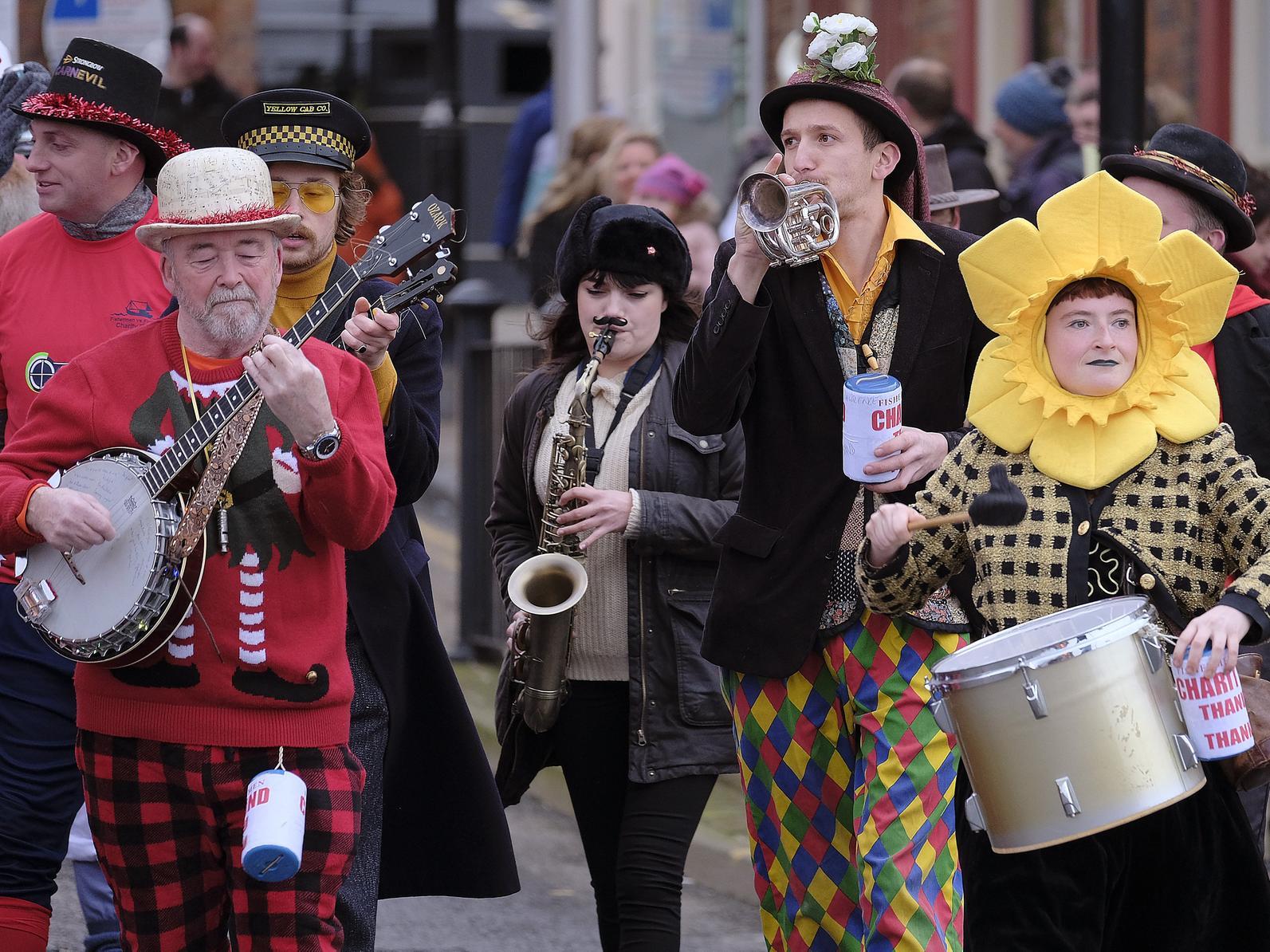 The comic band lead the teams through town.