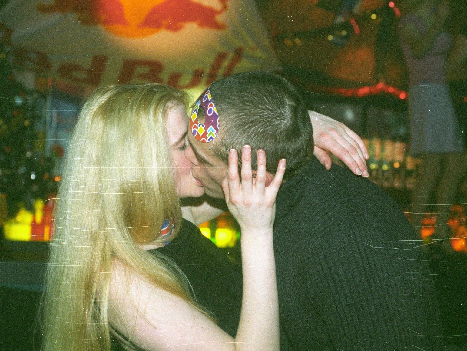 Another couple share a passionate kiss as the clock strikes midnight.