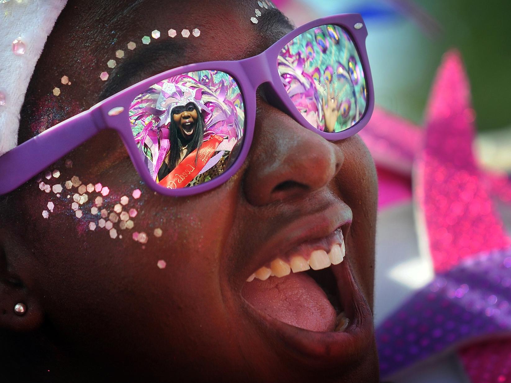Leeds West Indian Carnival queen Tahiela Odain Hamilton is reflected in the glasses of Eleanor Claxton.