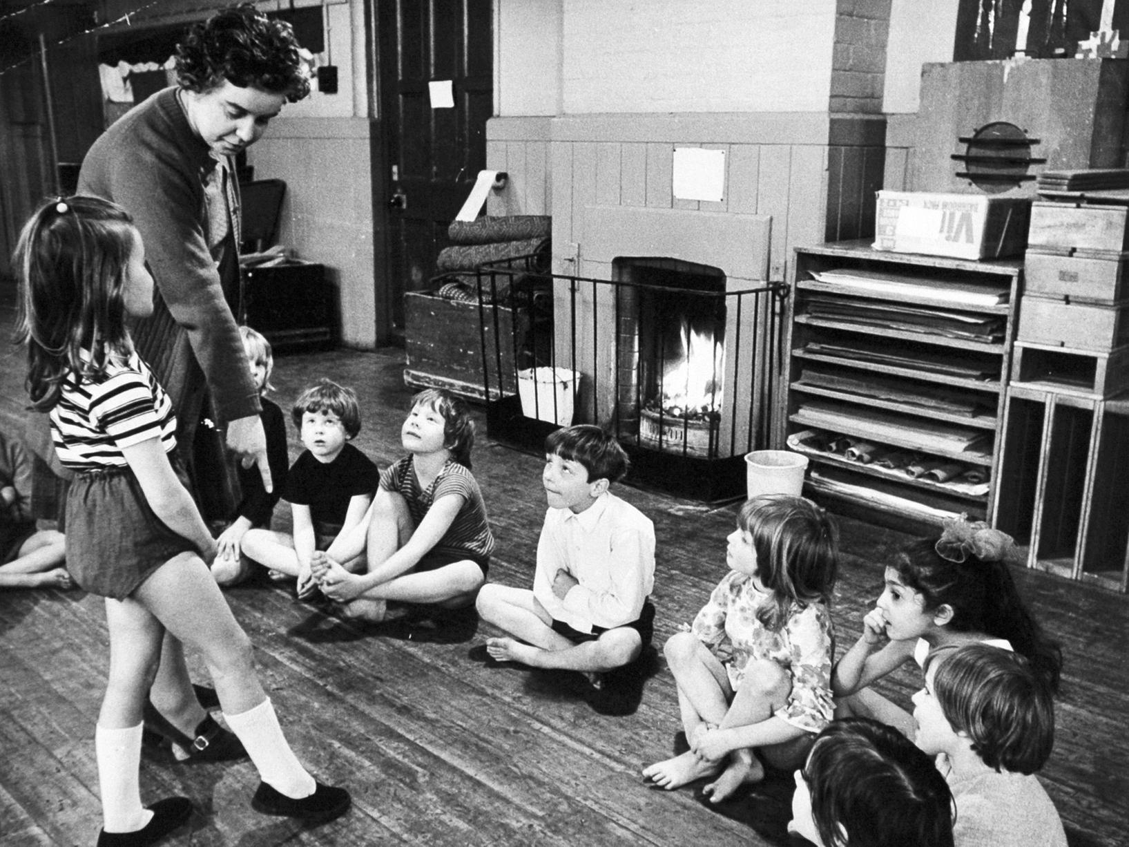 A teacher at Armley Church of England Primary on Wesley Road gives instructions in one of the classrooms heated by an open fire.