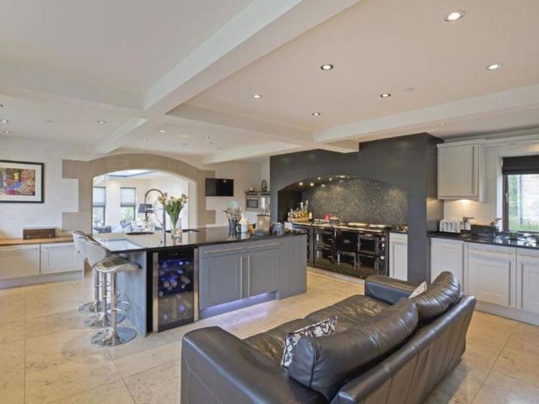 The beautifully modern kitchen features fitted appliances, including a full electric Aga, dishwasher, coffee maker, microwave over, wine cooler and plenty of storage cupboards.